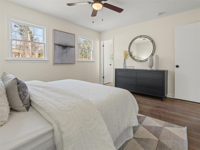 bedroom featuring wood finished floors, a ceiling fan, and baseboards