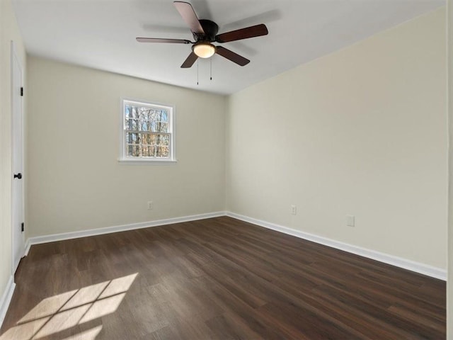 spare room with dark wood-style floors, a ceiling fan, and baseboards