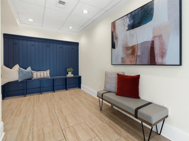 living area with baseboards, recessed lighting, and a drop ceiling