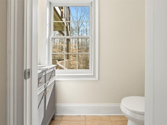 bathroom with baseboards, toilet, and tile patterned flooring