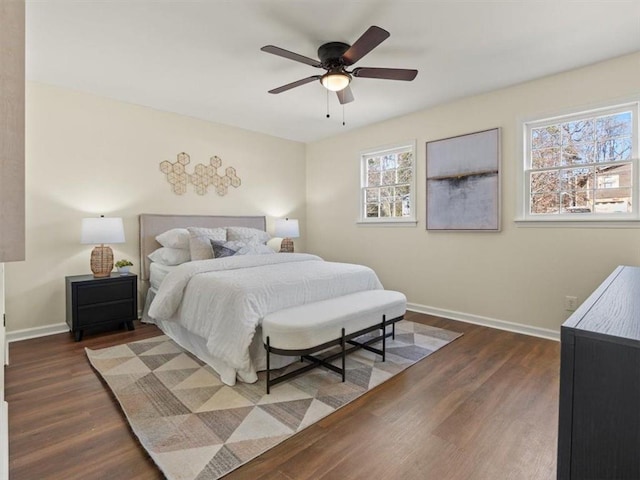 bedroom with dark wood-type flooring, baseboards, and ceiling fan