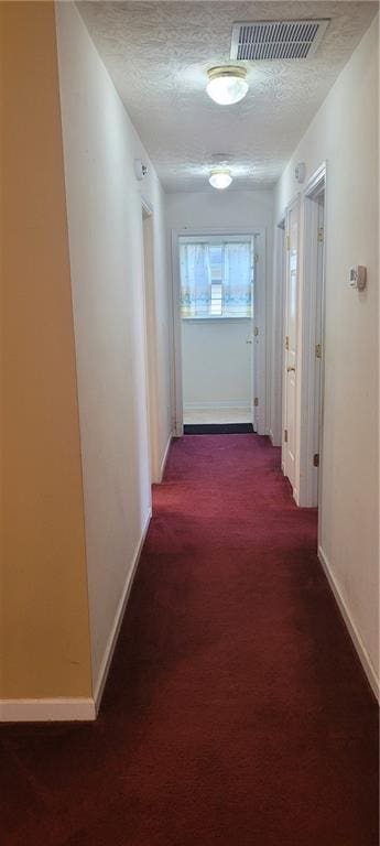 2703 Hillvale Cove Dr, Lithonia, GA 30058 - hallway featuring baseboards, dark carpet, and a textured ceiling