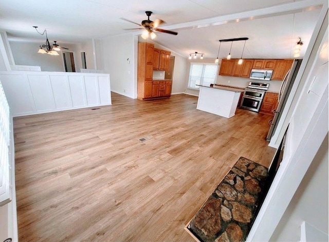 3735 Fir Dr, Buford, GA 30518 - kitchen featuring open floor plan, light wood-style floors, brown cabinets, and appliances with stainless steel finishes
