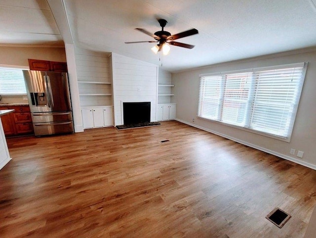 3735 Fir Dr, Buford, GA 30518 - unfurnished living room featuring built in features, vaulted ceiling, a ceiling fan, light wood-style floors, and visible vents