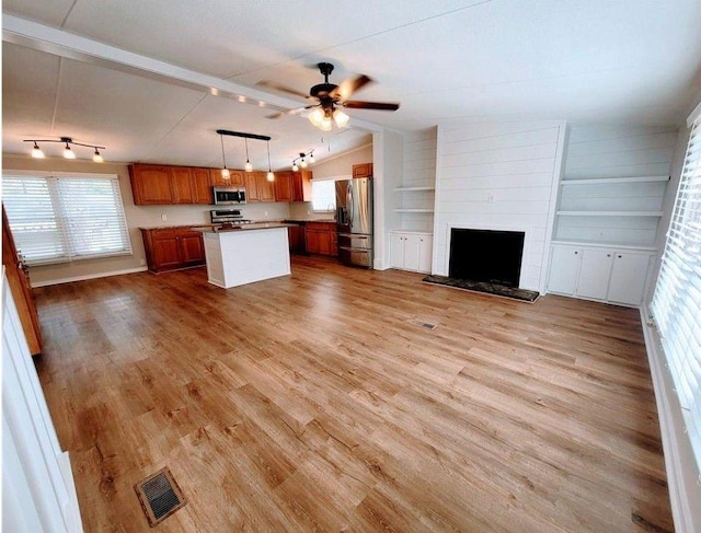 3735 Fir Dr, Buford, GA 30518 - kitchen with vaulted ceiling, visible vents, wood finished floors, stainless steel appliances, and open floor plan