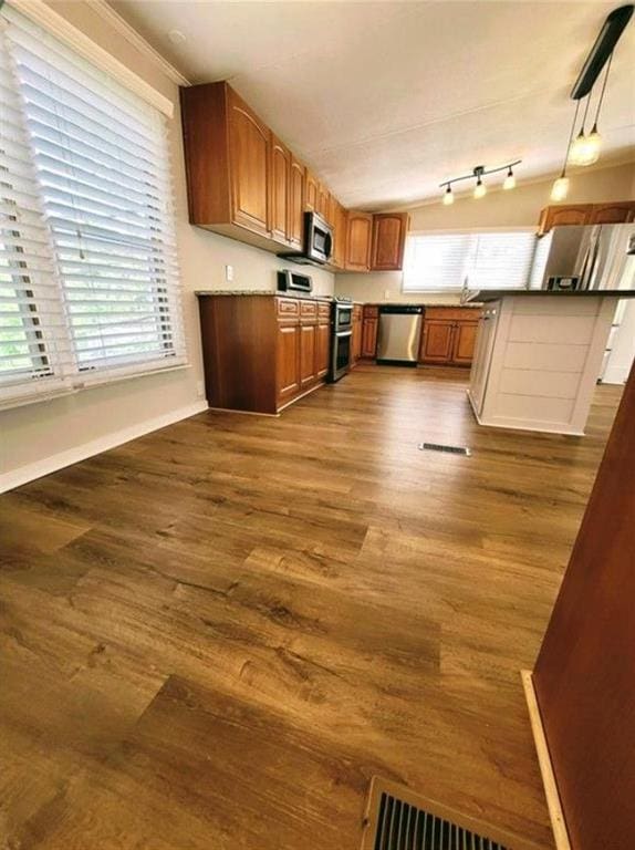 3735 Fir Dr, Buford, GA 30518 - kitchen with brown cabinets, pendant lighting, dark wood-style floors, and stainless steel appliances