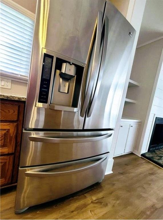 3735 Fir Dr, Buford, GA 30518 - room details featuring stainless steel fridge with ice dispenser, brown cabinetry, and wood finished floors