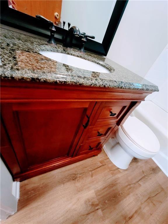 3735 Fir Dr, Buford, GA 30518 - bathroom featuring toilet, vanity, and wood finished floors