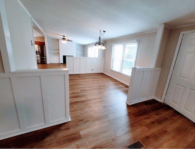 3735 Fir Dr, Buford, GA 30518 - unfurnished dining area with ornamental molding, visible vents, built in shelves, ceiling fan with notable chandelier, and wood finished floors