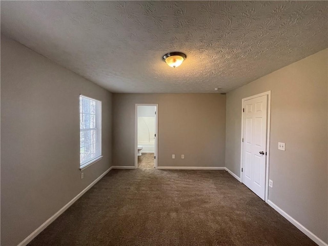 1374 To Lani Farm Rd, Stone Mountain, GA 30083 - spare room with baseboards, dark carpet, and a textured ceiling