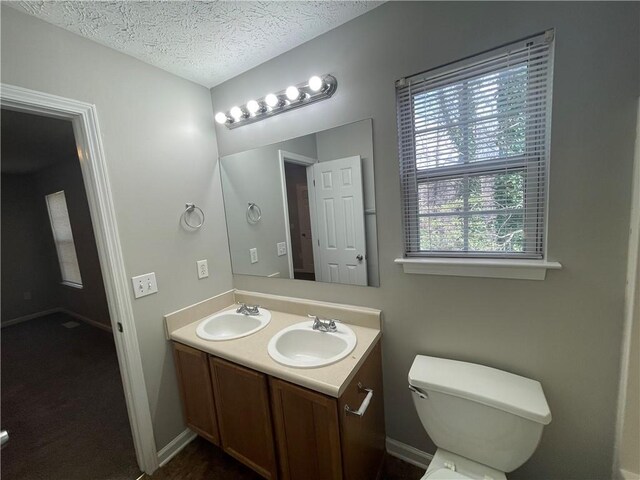 1374 To Lani Farm Rd, Stone Mountain, GA 30083 - bathroom featuring double vanity, toilet, a sink, and a textured ceiling