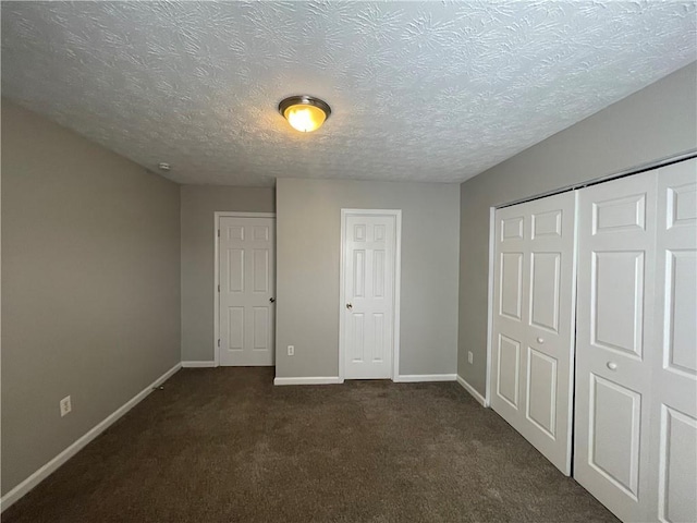 1374 To Lani Farm Rd, Stone Mountain, GA 30083 - unfurnished bedroom with a closet, baseboards, dark carpet, and a textured ceiling