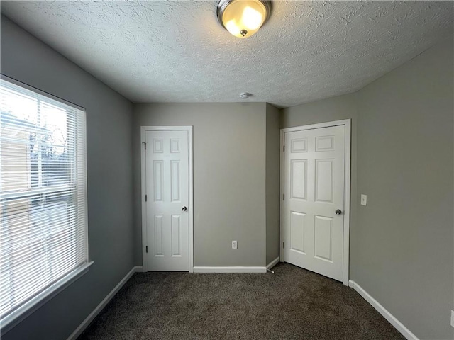 1374 To Lani Farm Rd, Stone Mountain, GA 30083 - unfurnished bedroom featuring baseboards, a textured ceiling, dark carpet, and a closet