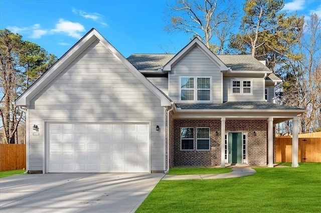 view of front facade with driveway, brick siding, a front yard, and fence