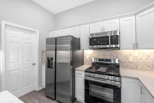 kitchen with stainless steel appliances, light countertops, white cabinets, and decorative backsplash