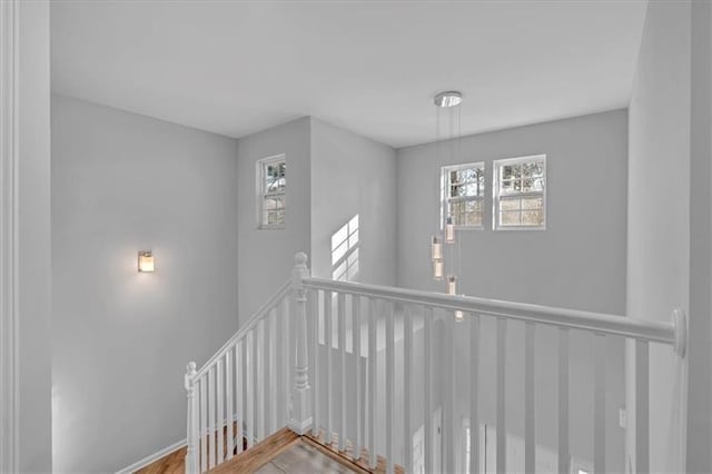 staircase with plenty of natural light, baseboards, and wood finished floors