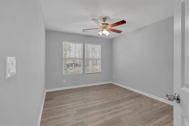 unfurnished room featuring light wood-style flooring, visible vents, baseboards, and a ceiling fan