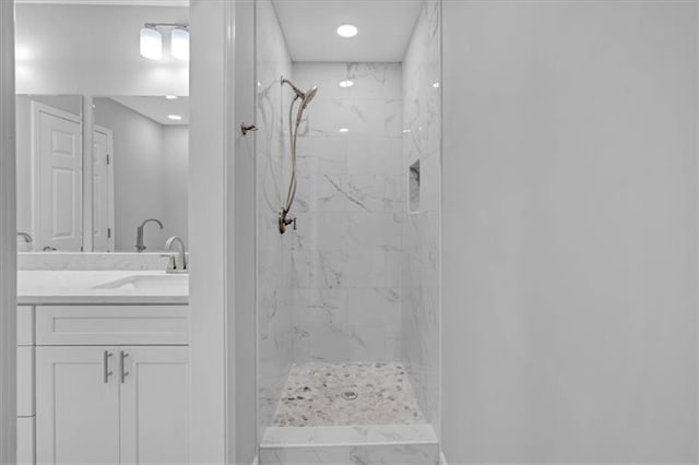 full bathroom featuring a marble finish shower and vanity