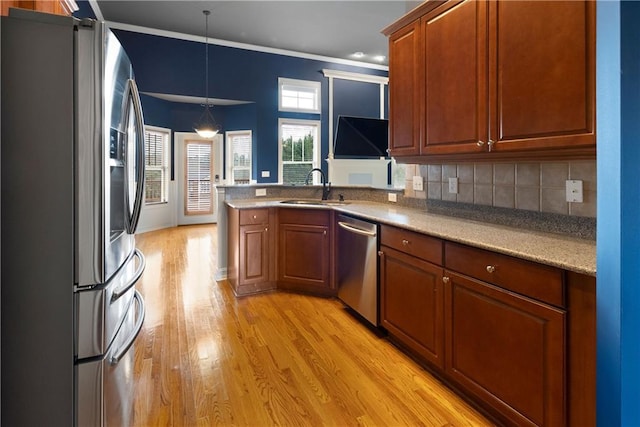 kitchen with tasteful backsplash, brown cabinetry, stainless steel appliances, light wood-style floors, and a sink