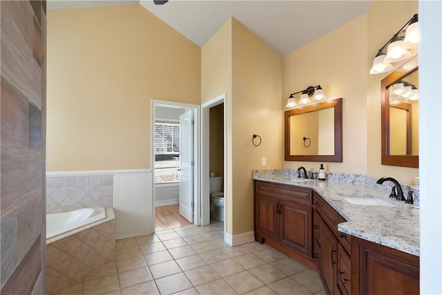 full bathroom featuring lofted ceiling, a sink, toilet, and tile patterned floors