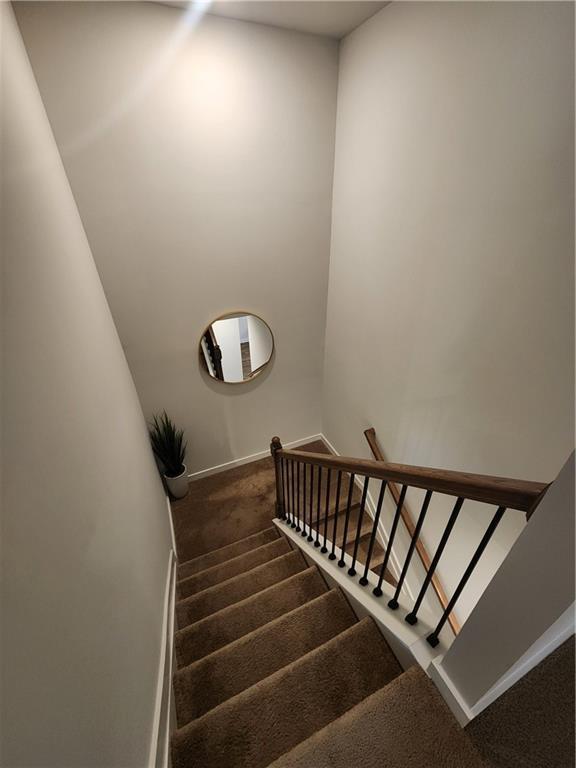 stairway featuring carpet flooring and baseboards
