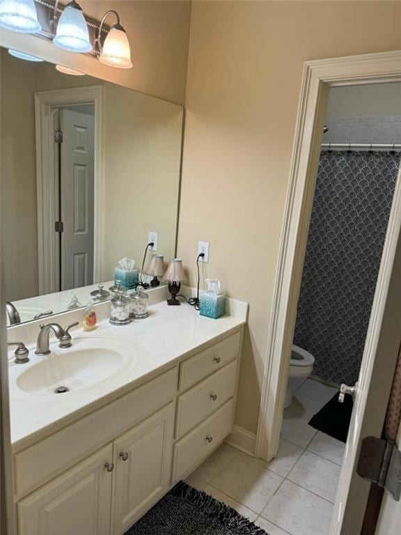 bathroom with tile patterned flooring, vanity, toilet, and walk in shower