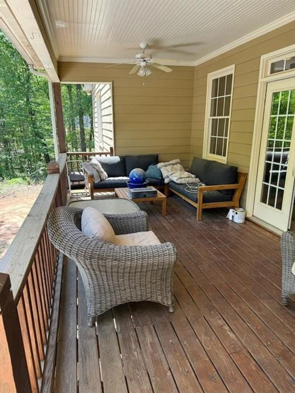 wooden deck featuring an outdoor living space and ceiling fan