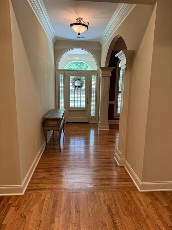 entrance foyer with hardwood / wood-style flooring, ornate columns, and crown molding