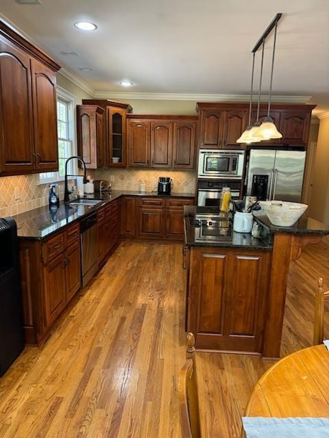 kitchen with pendant lighting, a kitchen island, stainless steel appliances, and sink