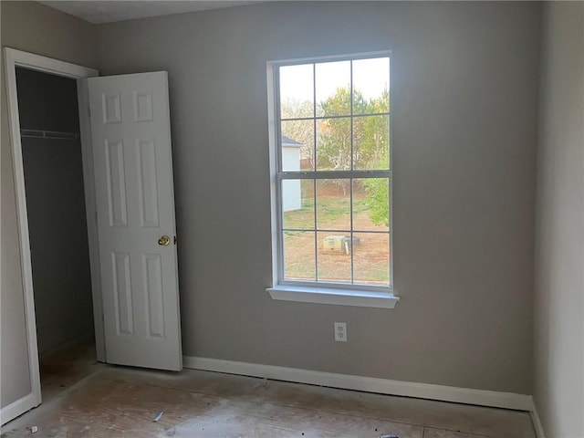 unfurnished bedroom featuring multiple windows and baseboards