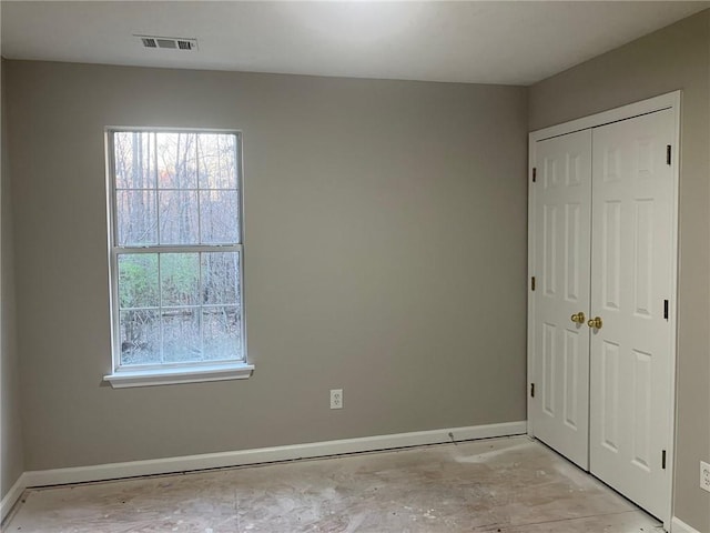 unfurnished bedroom featuring a closet, multiple windows, and baseboards