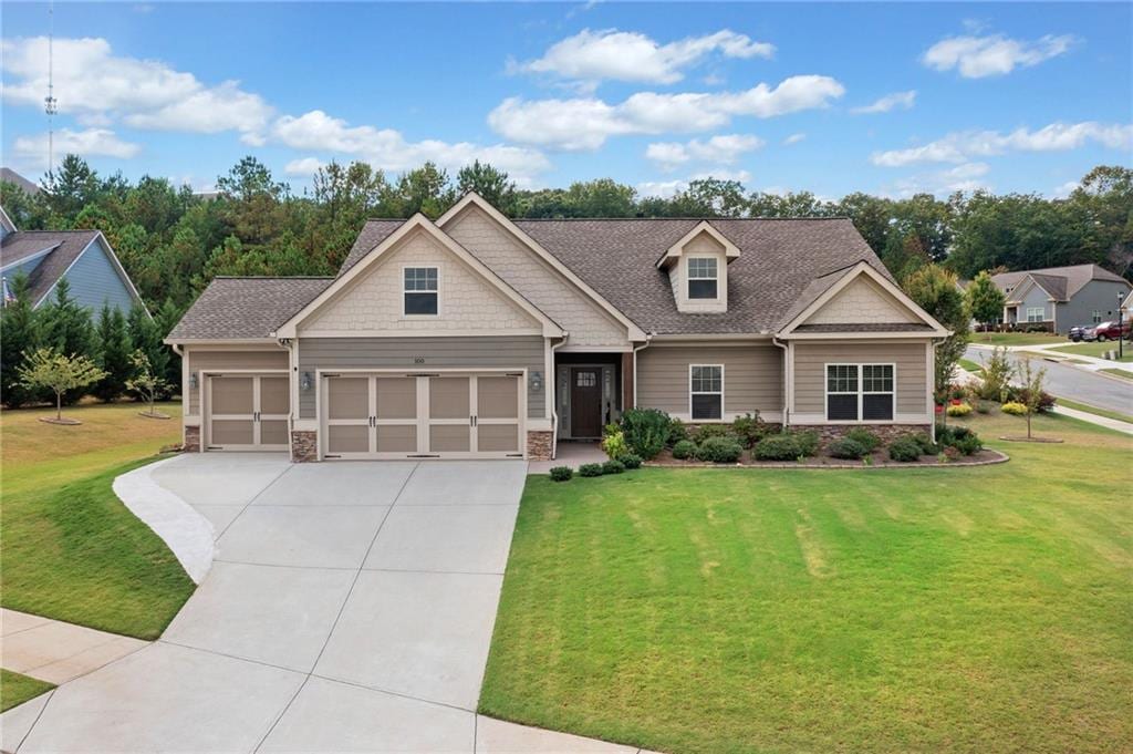 craftsman inspired home with a garage and a front lawn