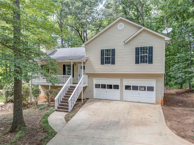 459 Bakers Bridge Cir, Douglasville, GA 30134 - split level home with an attached garage, a porch, concrete driveway, stairs, and view of wooded area