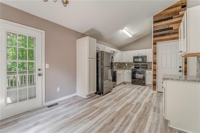 459 Bakers Bridge Cir, Douglasville, GA 30134 - kitchen with black appliances, lofted ceiling, light wood finished floors, decorative backsplash, and white cabinets