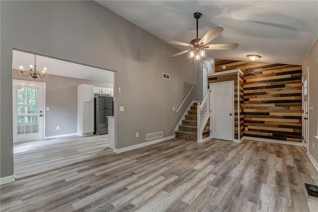 459 Bakers Bridge Cir, Douglasville, GA 30134 - unfurnished living room with light wood-type flooring, stairs, ceiling fan, high vaulted ceiling, and a chandelier