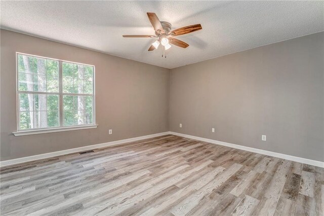 459 Bakers Bridge Cir, Douglasville, GA 30134 - spare room featuring plenty of natural light, light wood-style floors, ceiling fan, a textured ceiling, and baseboards
