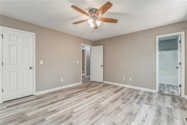459 Bakers Bridge Cir, Douglasville, GA 30134 - unfurnished bedroom featuring light wood-style flooring, baseboards, a textured ceiling, ensuite bath, and ceiling fan