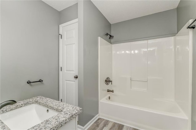 459 Bakers Bridge Cir, Douglasville, GA 30134 - full bathroom featuring wood finished floors, bathtub / shower combination, vanity, baseboards, and a textured ceiling