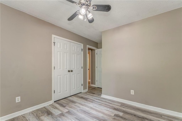 459 Bakers Bridge Cir, Douglasville, GA 30134 - unfurnished bedroom with wood finished floors, baseboards, a closet, a textured ceiling, and ceiling fan