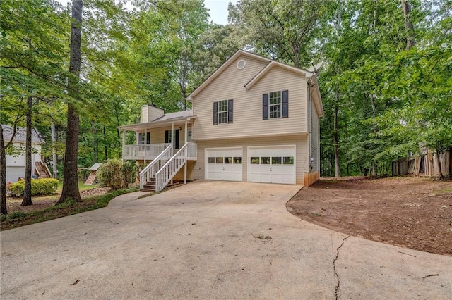 459 Bakers Bridge Cir, Douglasville, GA 30134 - tri-level home with covered porch, stairs, a garage, concrete driveway, and a chimney