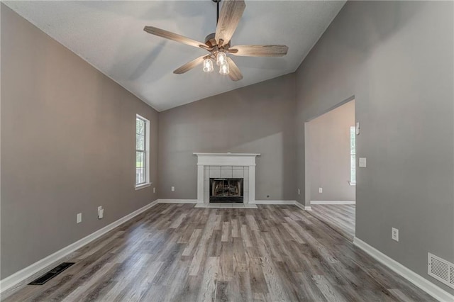 459 Bakers Bridge Cir, Douglasville, GA 30134 - unfurnished living room featuring wood finished floors, ceiling fan, baseboards, a tile fireplace, and high vaulted ceiling