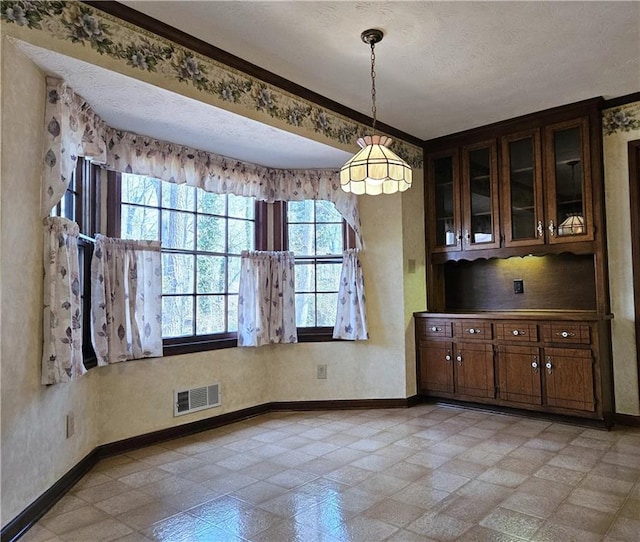 unfurnished dining area with a textured ceiling