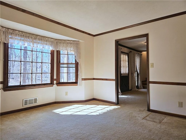 empty room featuring crown molding and light carpet