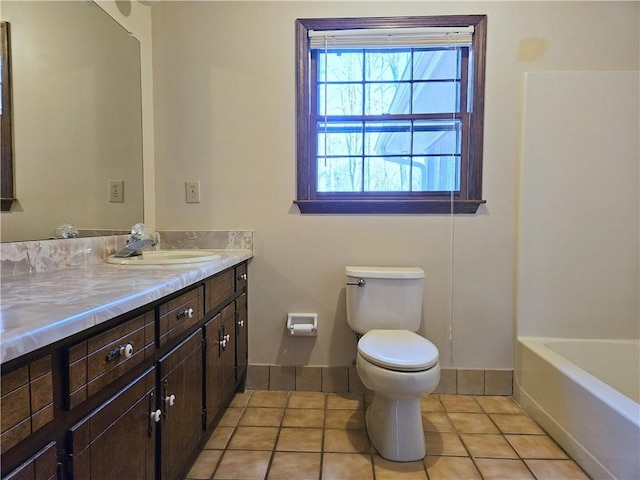 bathroom featuring vanity, a tub to relax in, tile patterned floors, and toilet