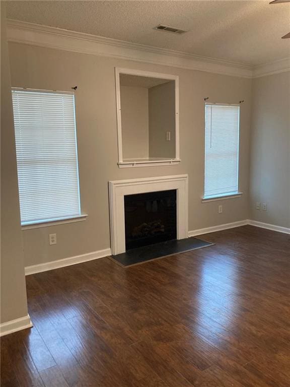 unfurnished living room with crown molding, dark hardwood / wood-style flooring, ceiling fan, and a textured ceiling