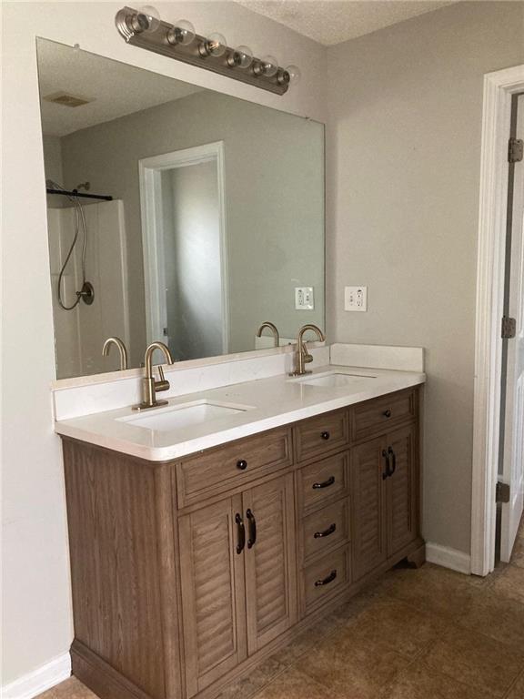 bathroom featuring a shower and vanity