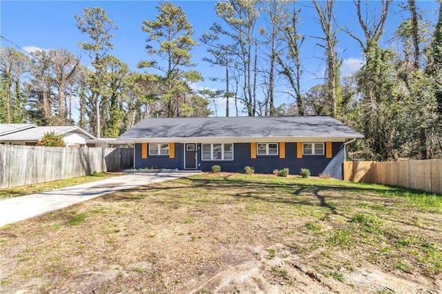 ranch-style house featuring fence, a front lawn, and concrete driveway