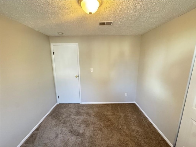 carpeted empty room with a textured ceiling