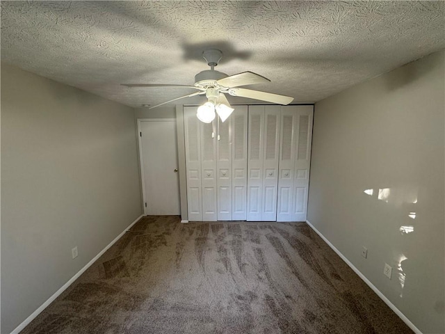 unfurnished bedroom with ceiling fan, carpet floors, a textured ceiling, and a closet