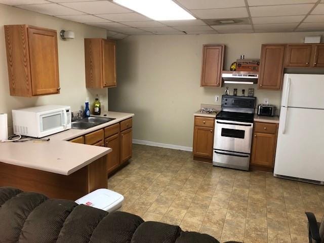 kitchen with kitchen peninsula, a paneled ceiling, white appliances, extractor fan, and sink